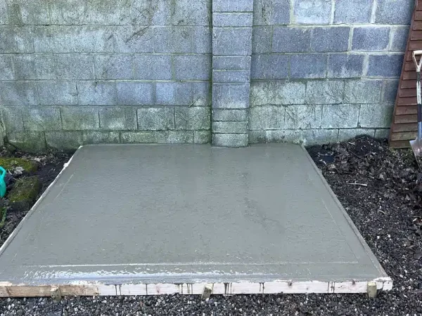 Freshly poured concrete and timber formwork for shed base in Dublin